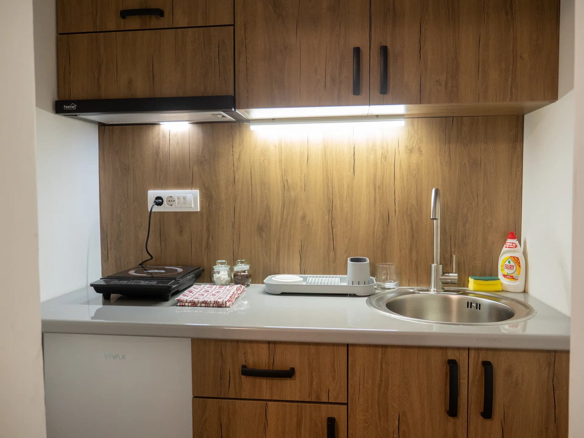 Apartment I — the kitchenette with a sink, a hob and wooden units