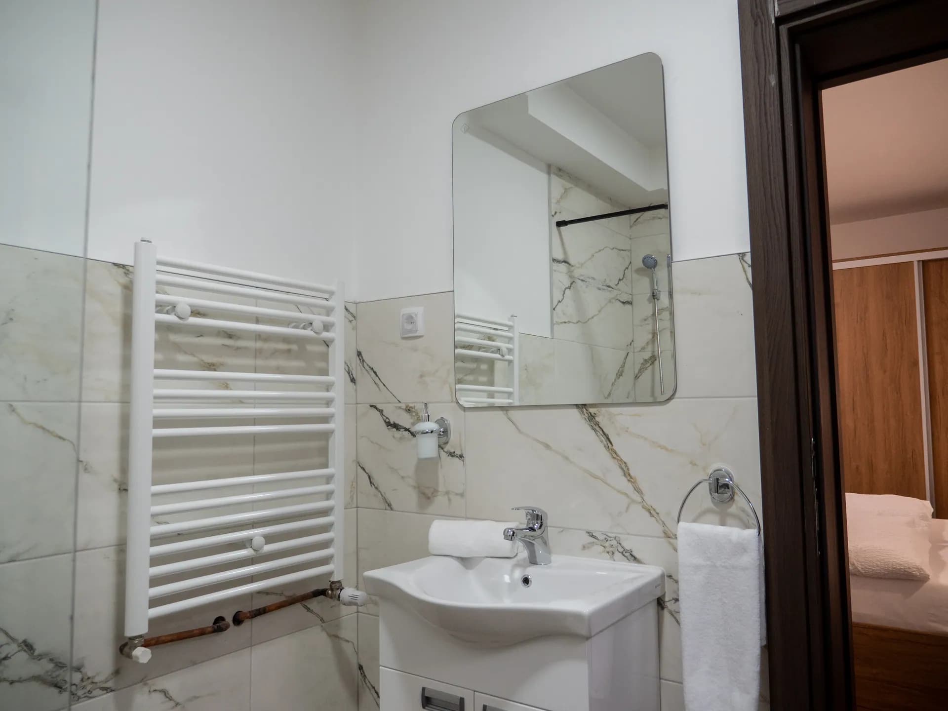 Apartment I — the washbasin with a mirror and a heated towel rail