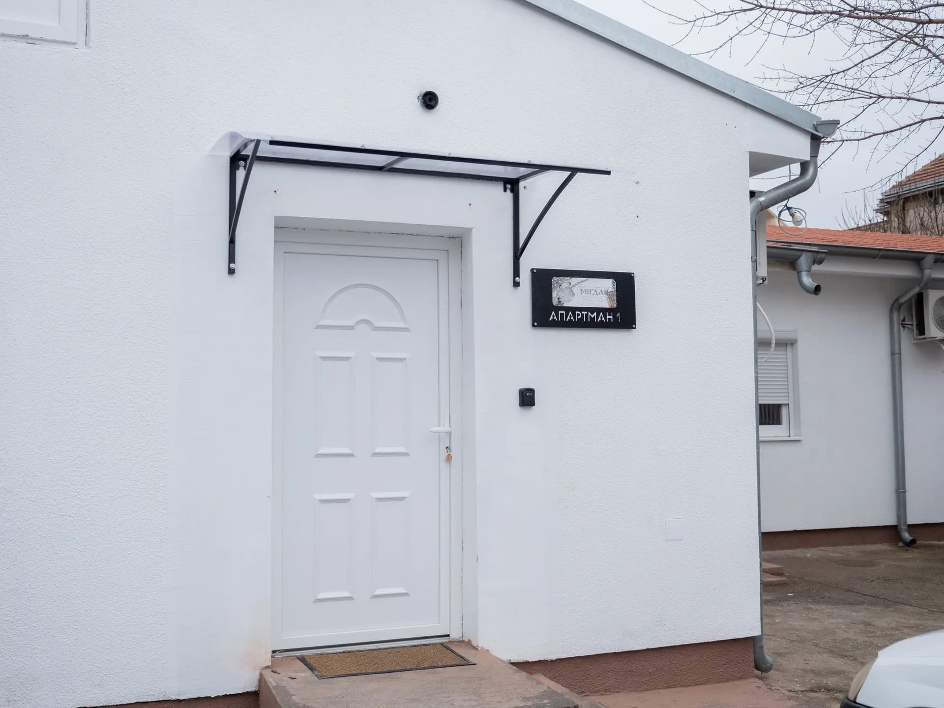Apartman I — zaseban ulaz sa nadstrešnicom i tablom sa nazivom apartmana