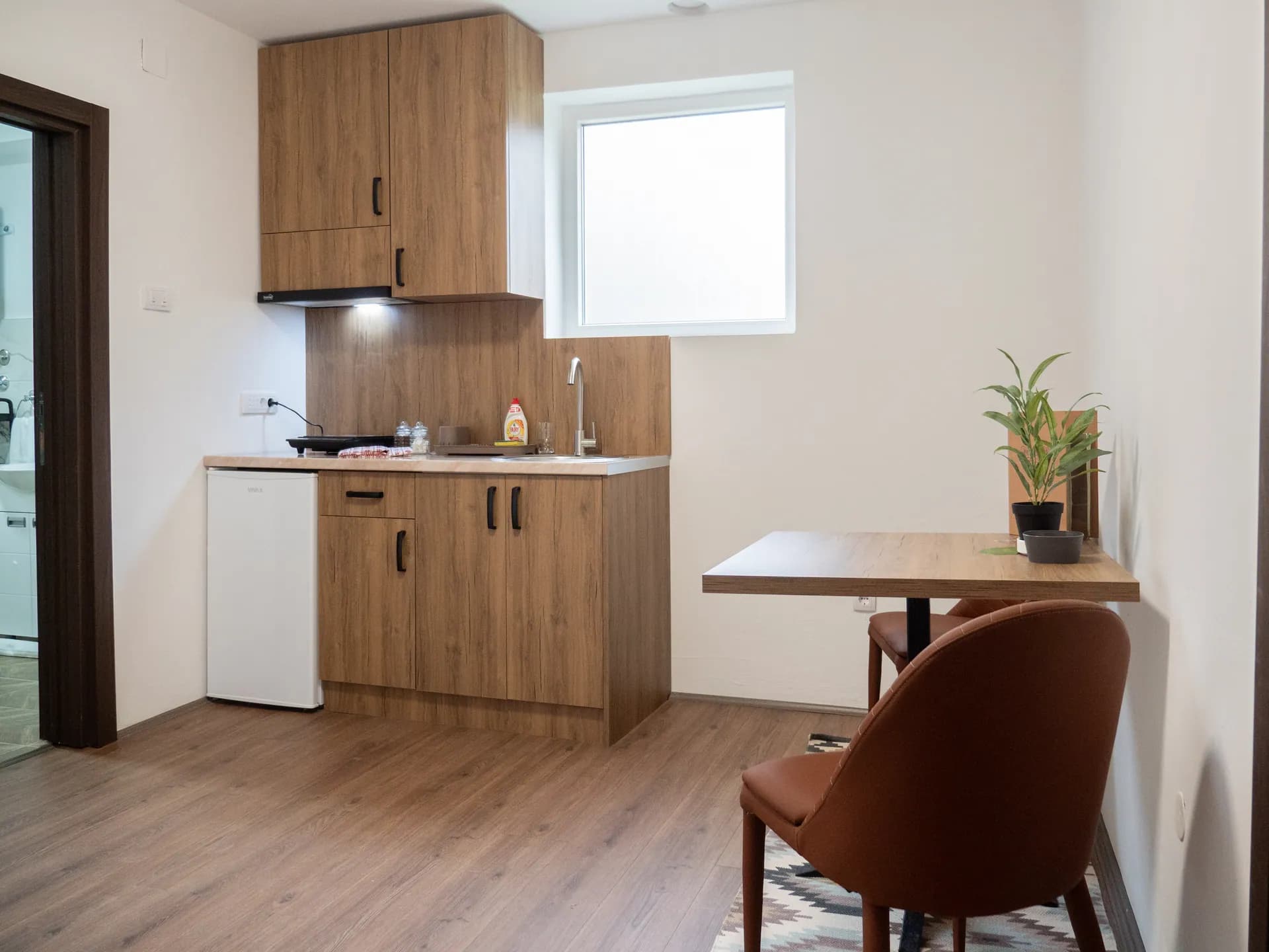 Apartman II — čajna kuhinja sa frižiderom i trpezarijski sto
