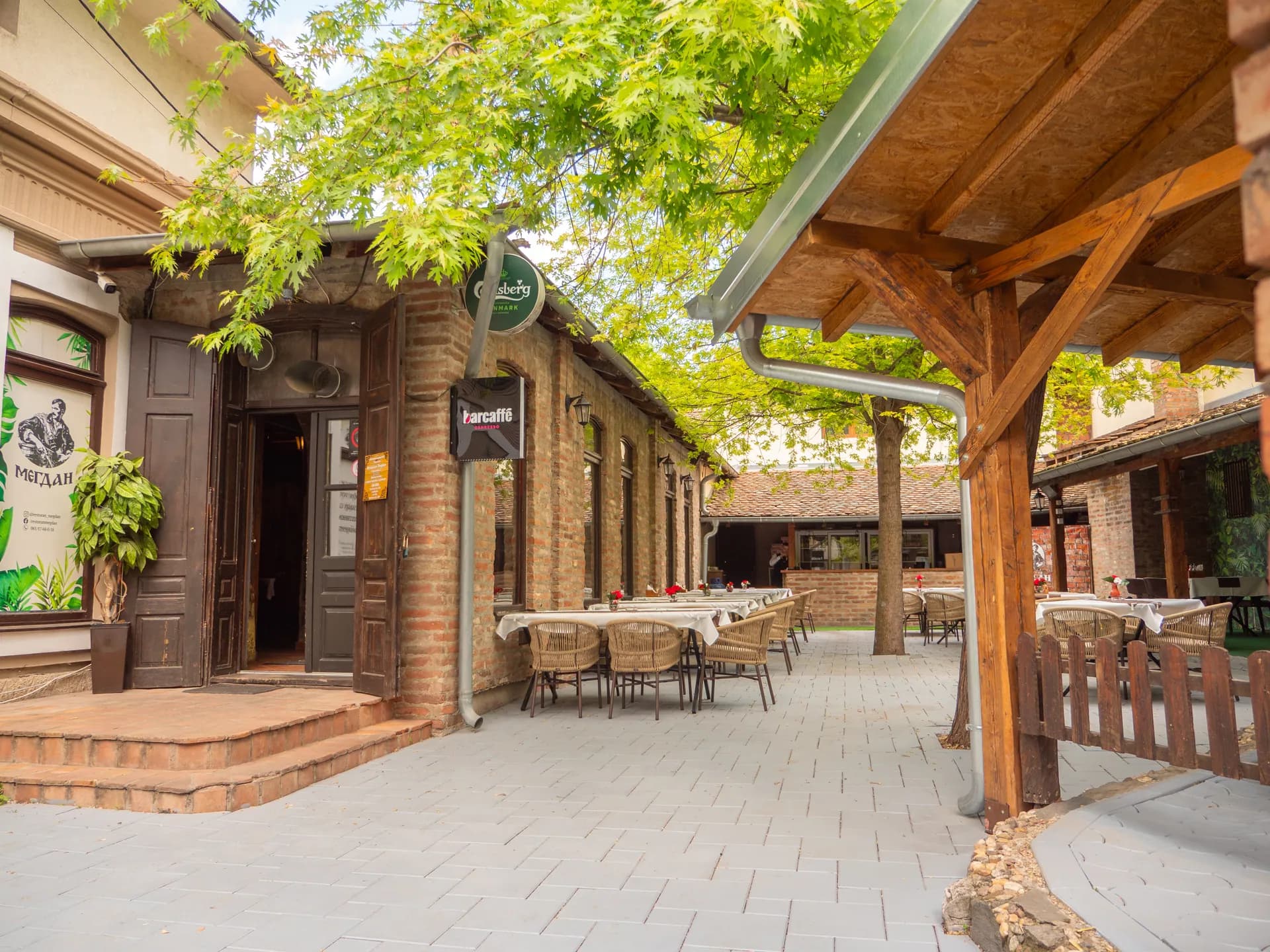 Ulaz u Restoran Megdan i bašta duž ciglane zgrade
