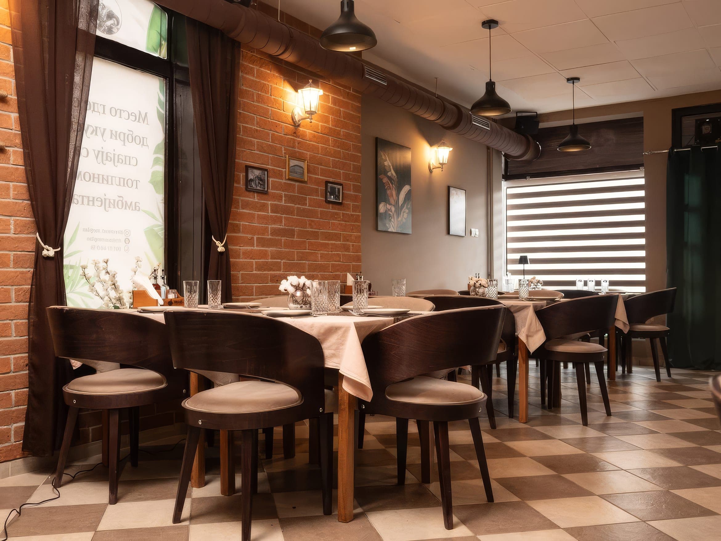 The smaller hall at Restaurant Megdan, with an exposed brick wall and a long table laid for guests